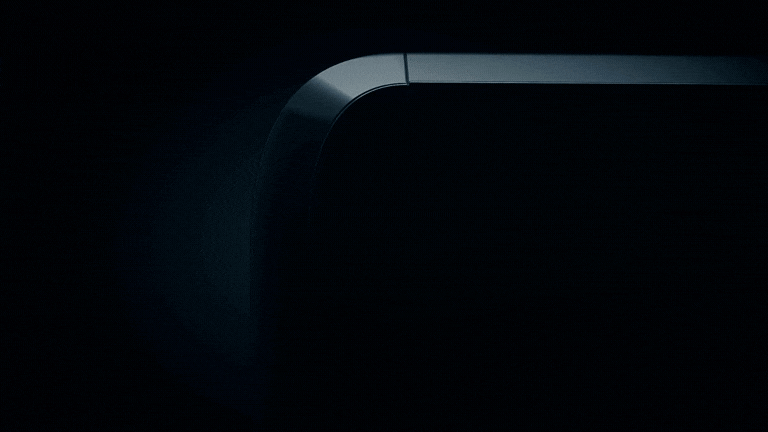 A dark metallic surface curves gently, with a light source casting a shadow on the right side.